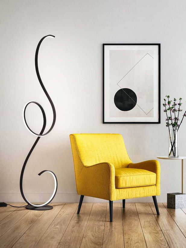 Wren black ribbon floor lamp beside a yellow armchair