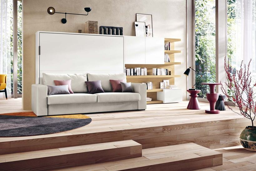 Yoga wall bed closed behind a pale grey sofa
