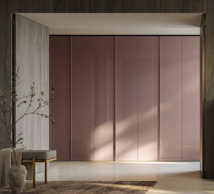 Lull hinged wardrobe with blush glass doors built into a recess