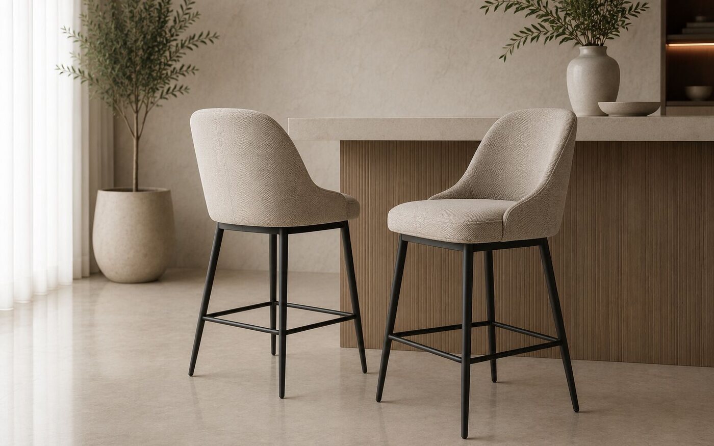 Two cream upholstered bar stools with black legs at a fluted kitchen island