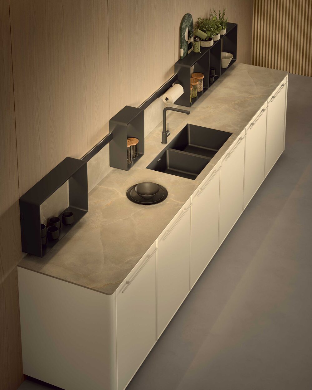 Long kitchen run with a stone worktop, inset sink and black rail shelving